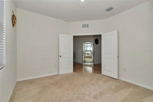 unfurnished room featuring light carpet