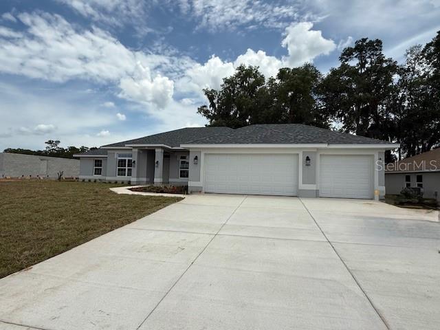 13 NW 45th Loop, Ocala, FL 34475 - single story home with a garage, concrete driveway, stucco siding, and a front lawn