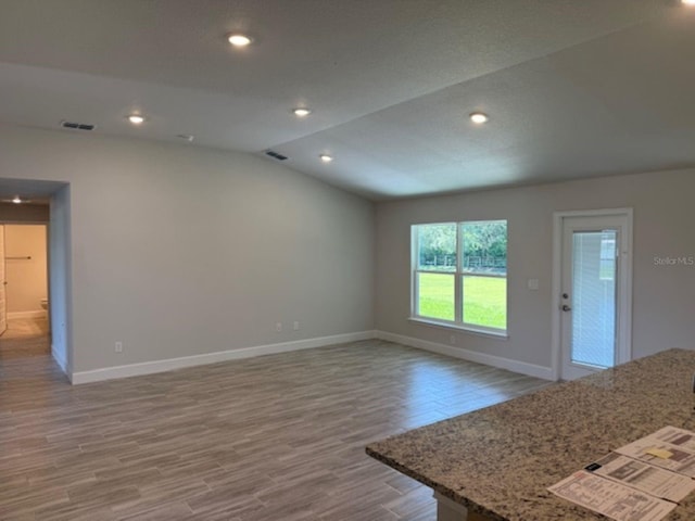 13 NW 45th Loop, Ocala, FL 34475 - unfurnished living room with wood finished floors, lofted ceiling, and recessed lighting