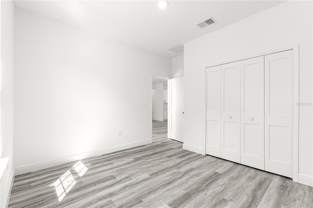 unfurnished bedroom featuring a closet and light hardwood / wood-style flooring