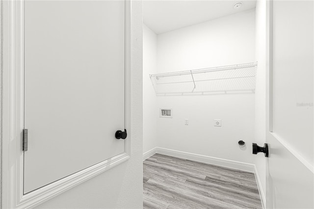 laundry area featuring electric dryer hookup, hookup for a washing machine, and light hardwood / wood-style floors