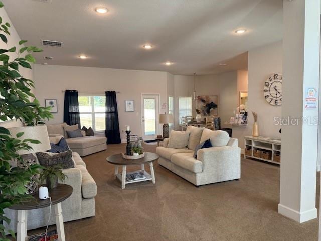 living room featuring carpet floors, visible vents, and recessed lighting