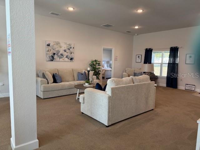 living room with recessed lighting, baseboards, visible vents, and carpet flooring