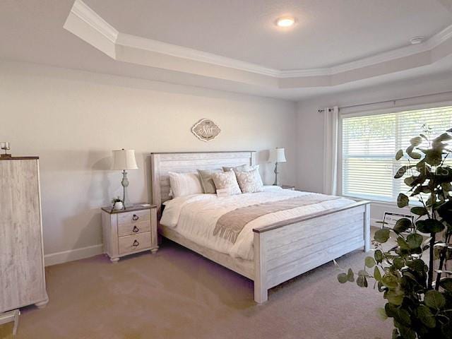 carpeted bedroom with baseboards, a tray ceiling, and crown molding