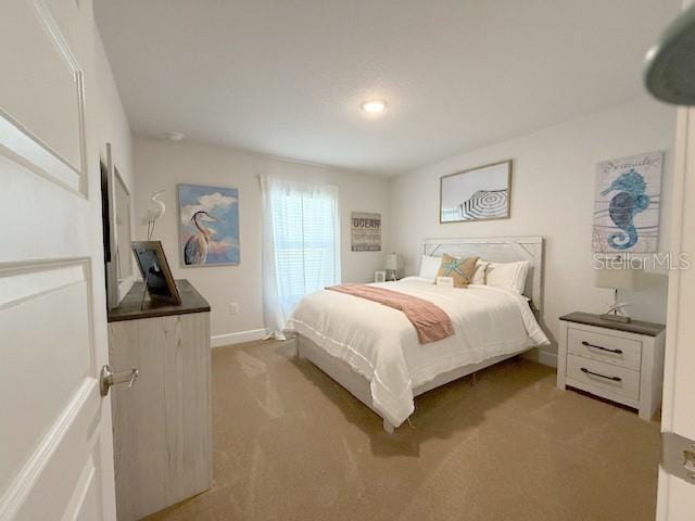 bedroom with carpet flooring and baseboards