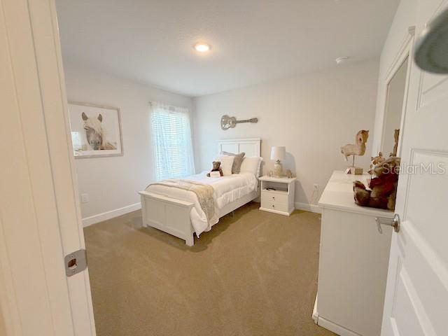 carpeted bedroom featuring baseboards