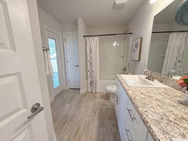 full bathroom with vanity, wood finished floors, toilet, and shower / tub combo with curtain