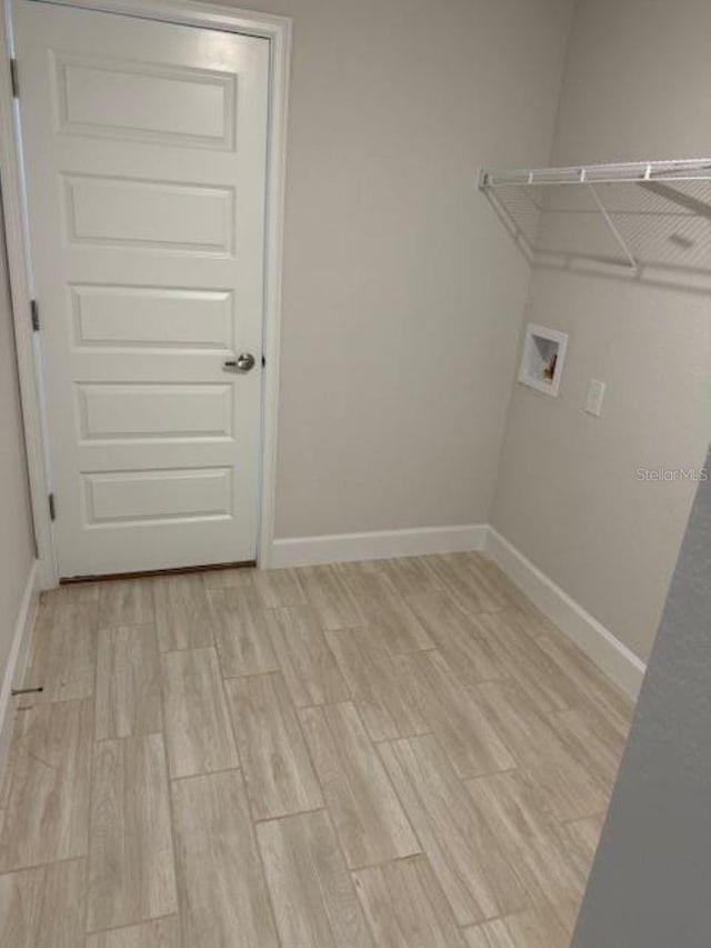 7 NW 45th Loop, Ocala, FL 34470 - laundry area featuring washer hookup, baseboards, and light wood-style floors