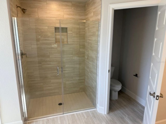 7 NW 45th Loop, Ocala, FL 34470 - bathroom featuring toilet, a shower stall, baseboards, and wood finished floors