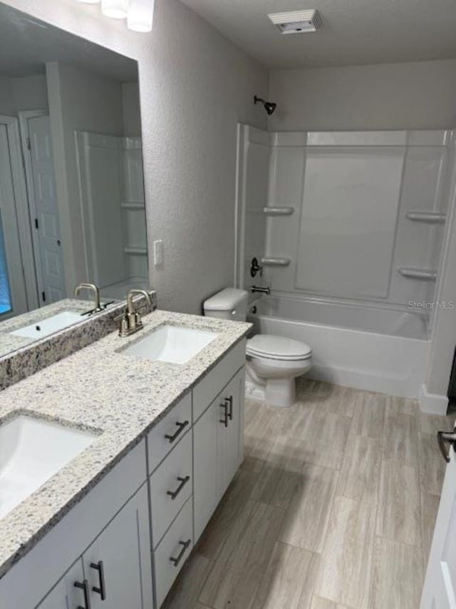 7 NW 45th Loop, Ocala, FL 34470 - full bathroom featuring double vanity, a textured wall, toilet, shower / tub combination, and wood finished floors