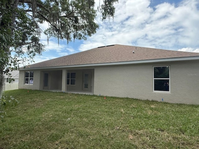 7 NW 45th Loop, Ocala, FL 34470 - back of house with stucco siding and a yard