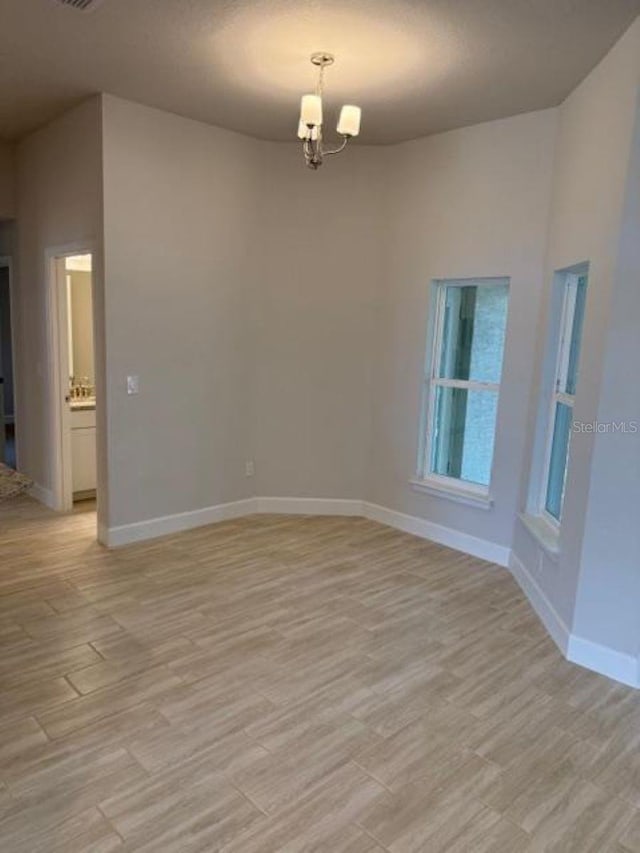 7 NW 45th Loop, Ocala, FL 34470 - empty room featuring a chandelier, baseboards, and light wood-style flooring
