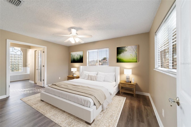 bedroom featuring multiple windows, dark wood-type flooring, and a textured ceiling