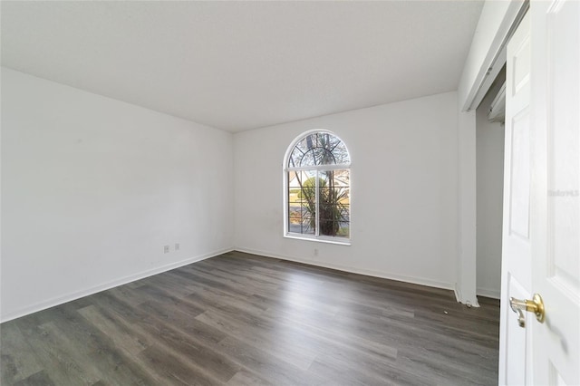 unfurnished room with dark hardwood / wood-style flooring