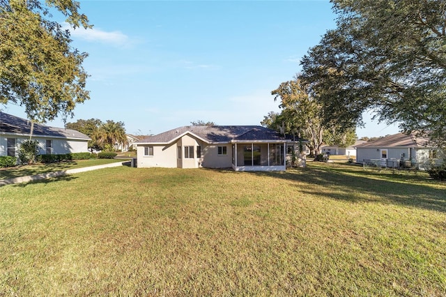 back of property with a yard and a sunroom