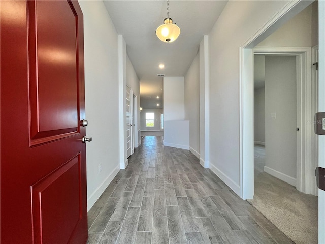 hallway with light wood-style flooring and baseboards