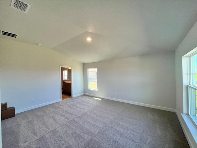 unfurnished room with baseboards, a healthy amount of sunlight, carpet floors, and lofted ceiling