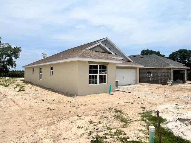 4373 SW 90th Pl, Ocala, FL 34476 - view of home's exterior with an attached garage, stucco siding, and a shingled roof