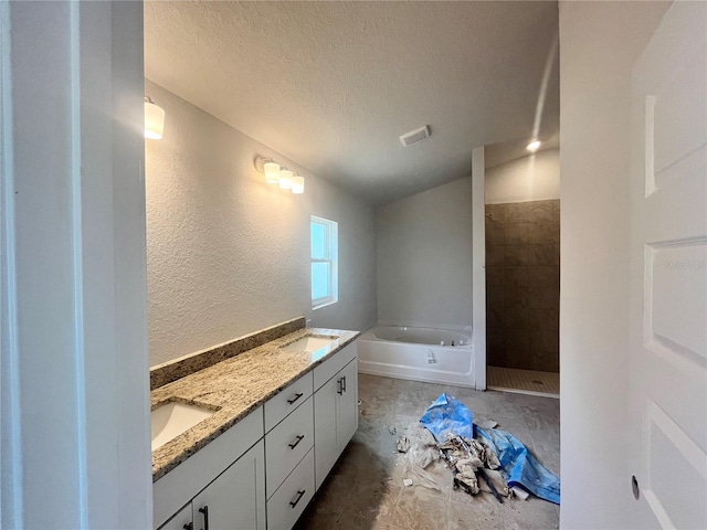 4373 SW 90th Pl, Ocala, FL 34476 - bathroom with a textured ceiling, a garden tub, a textured wall, double vanity, and lofted ceiling
