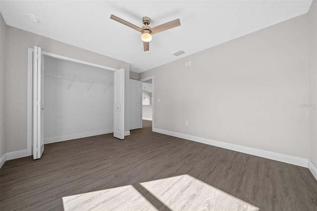 unfurnished bedroom with dark wood-type flooring, a closet, and ceiling fan