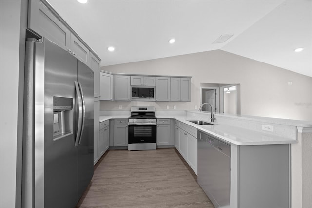 kitchen featuring stainless steel appliances, sink, gray cabinetry, and kitchen peninsula