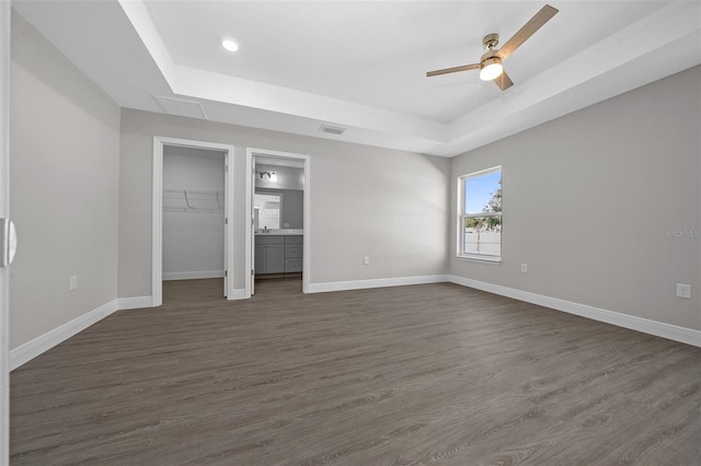 unfurnished bedroom with dark hardwood / wood-style flooring, a raised ceiling, and sink