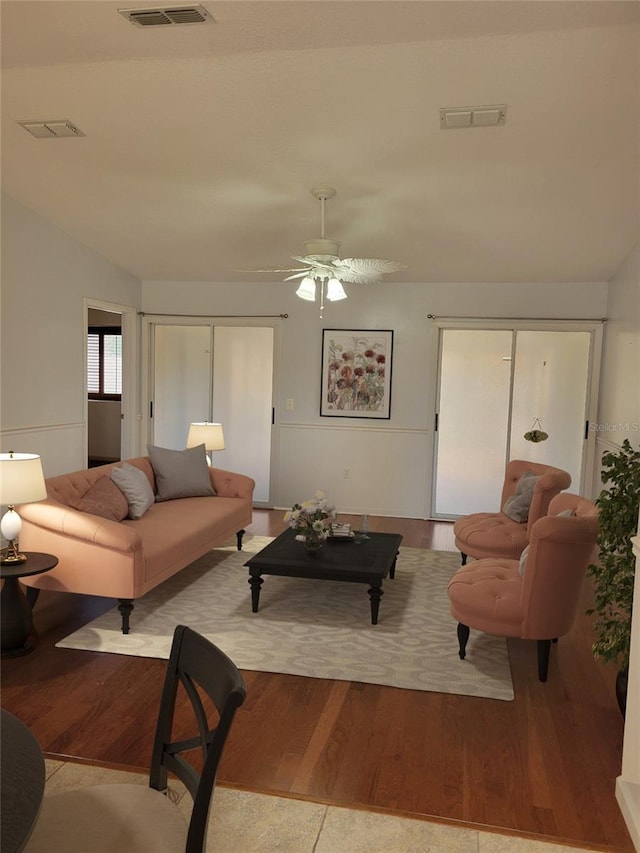 living room with ceiling fan, lofted ceiling, and light hardwood / wood-style floors