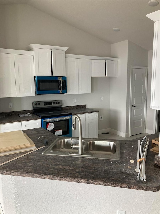 kitchen with white cabinetry, stainless steel electric range oven, lofted ceiling, and sink