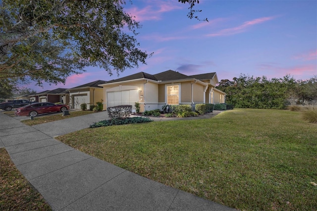 ranch-style house with a yard and a garage