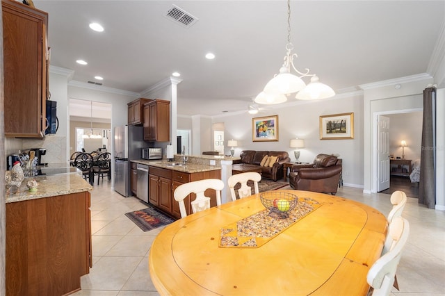 tiled dining space with ornamental molding and ceiling fan with notable chandelier