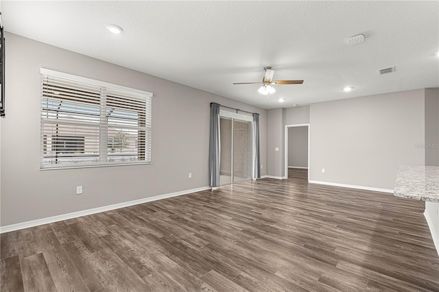 interior space featuring dark wood-type flooring, ceiling fan, and a textured ceiling