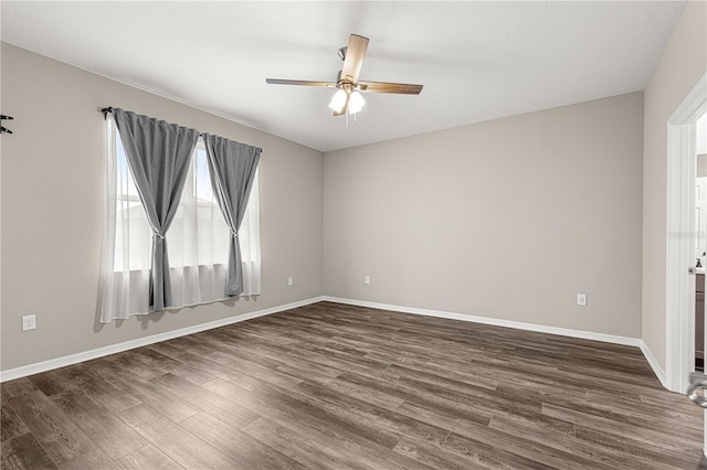 empty room with ceiling fan and dark hardwood / wood-style flooring