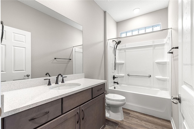 full bathroom featuring toilet, shower / bathing tub combination, a textured ceiling, vanity, and hardwood / wood-style floors