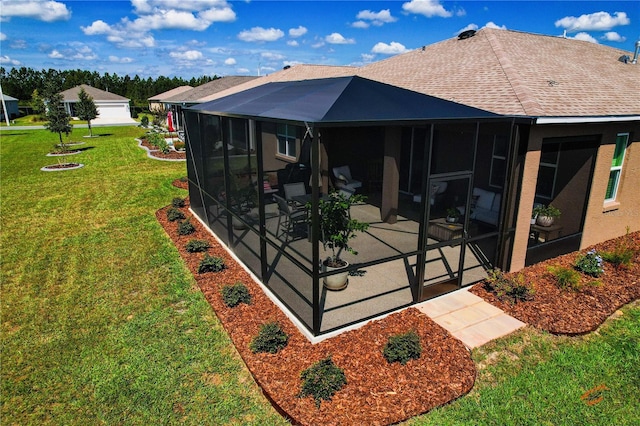 back of property with a patio, a sunroom, and a lawn