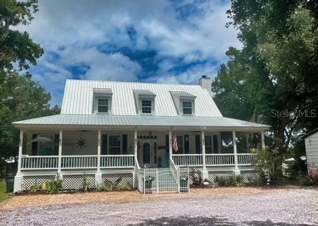 country-style home featuring ceiling fan and covered porch