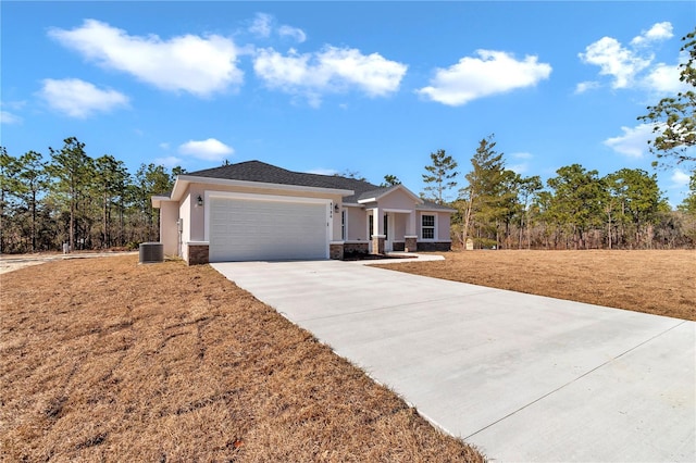 view of front of house featuring central AC unit, a garage, and a front lawn