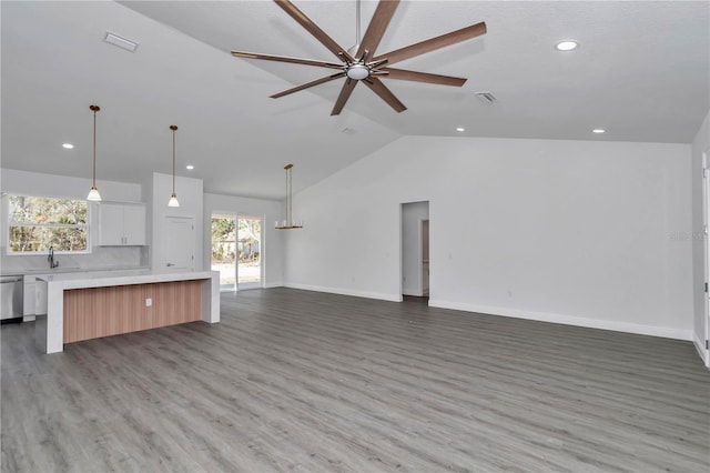 unfurnished living room featuring hardwood / wood-style flooring, ceiling fan, lofted ceiling, and sink