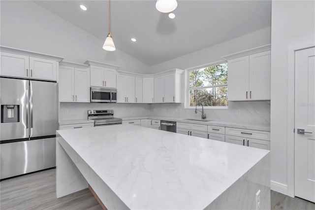 kitchen featuring hanging light fixtures, white cabinets, and appliances with stainless steel finishes