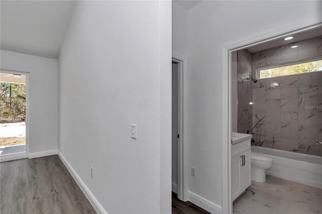 full bathroom featuring vanity, tiled shower / bath combo, a wealth of natural light, and toilet