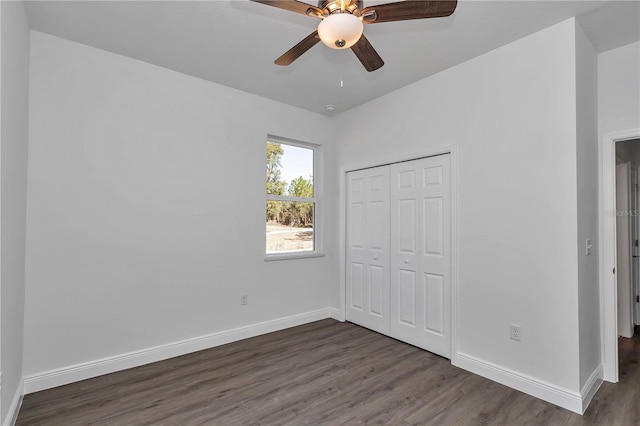 unfurnished bedroom featuring dark hardwood / wood-style floors, ceiling fan, and a closet