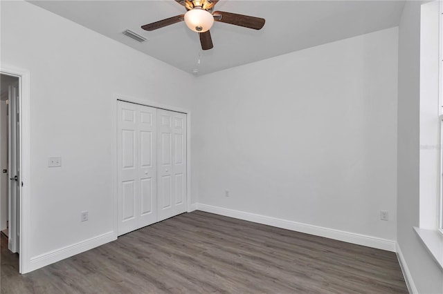 unfurnished bedroom featuring hardwood / wood-style flooring, a closet, and ceiling fan