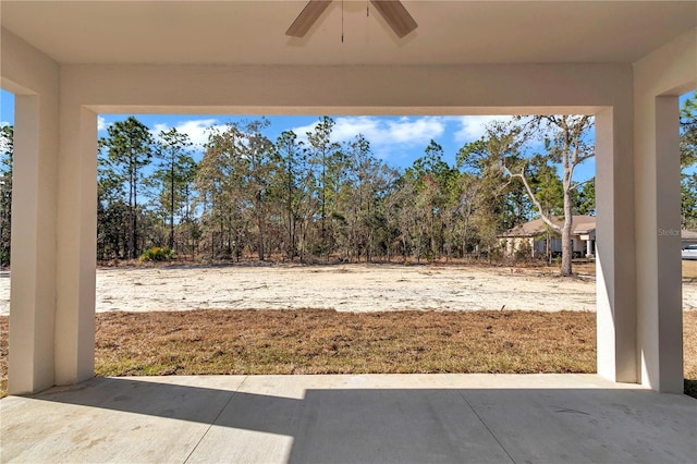 view of yard featuring ceiling fan and a patio