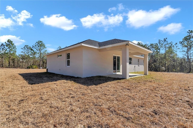 view of property exterior with a yard and a patio