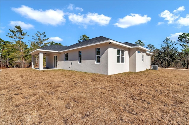 rear view of property with a yard and central air condition unit