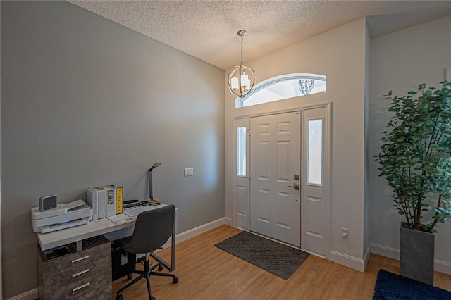 foyer featuring hardwood / wood-style flooring, lofted ceiling, and a textured ceiling