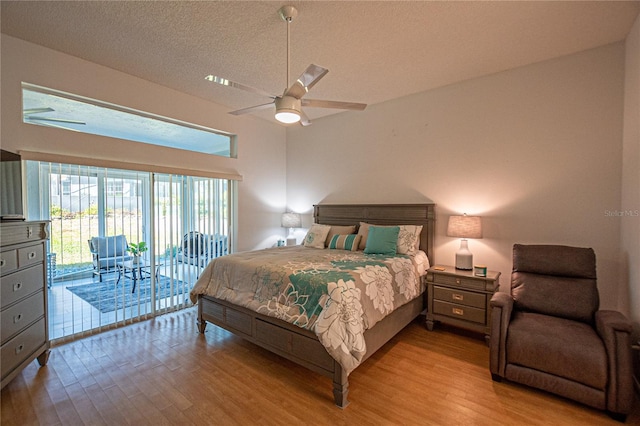 bedroom featuring ceiling fan, a textured ceiling, light hardwood / wood-style flooring, and access to outside