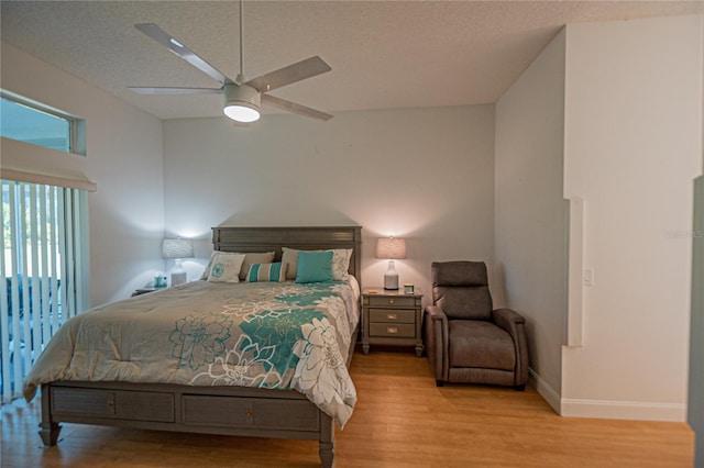 bedroom featuring ceiling fan, a textured ceiling, and light hardwood / wood-style flooring