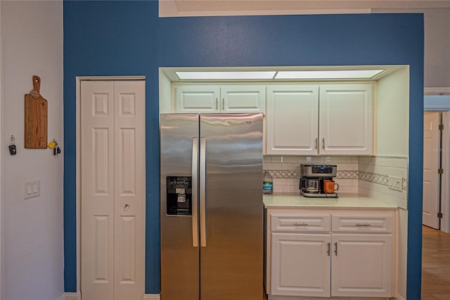 kitchen with white cabinets, wood-type flooring, decorative backsplash, and stainless steel fridge with ice dispenser