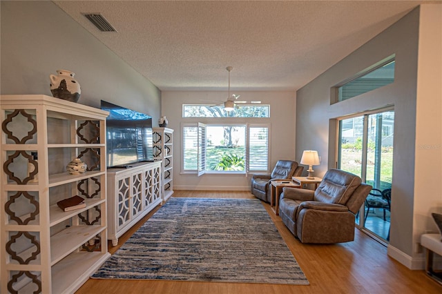 living room featuring hardwood / wood-style flooring, a healthy amount of sunlight, and a textured ceiling