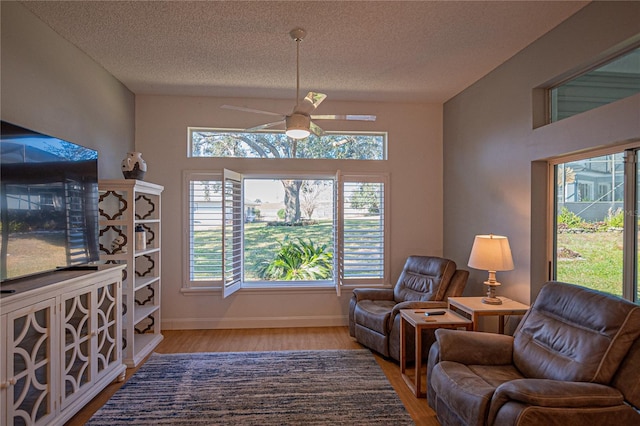 sitting room featuring ceiling fan, hardwood / wood-style floors, and a textured ceiling